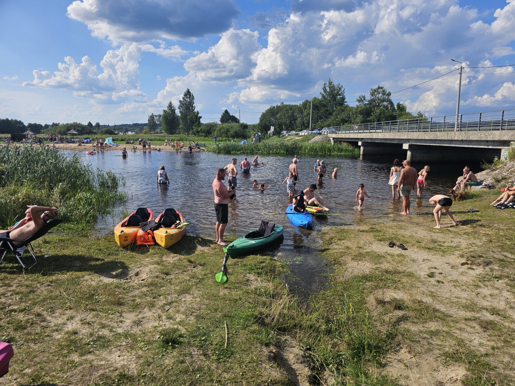 Grupa kajakarzy machająca na rzece